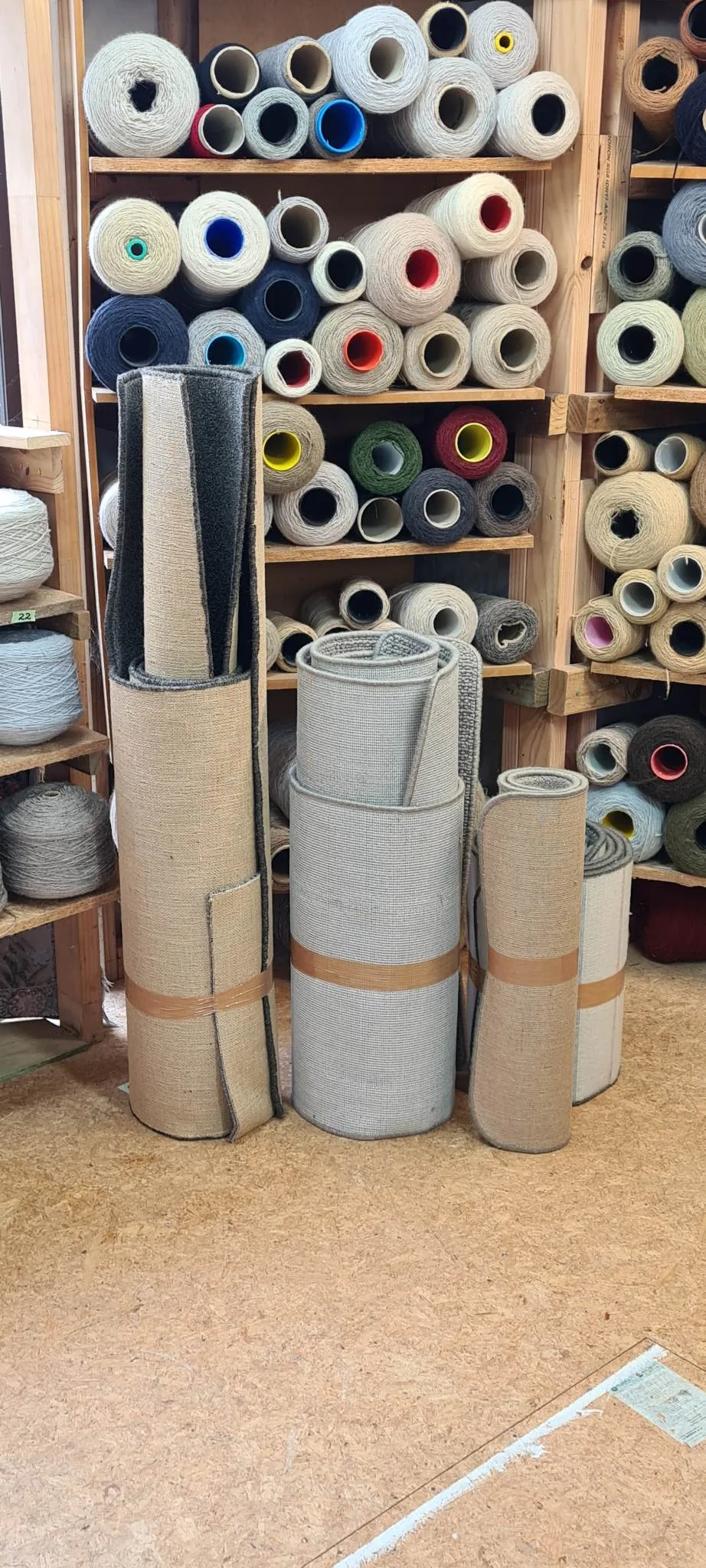 Yarn spools and carpet rolls ready for professional overlocking service