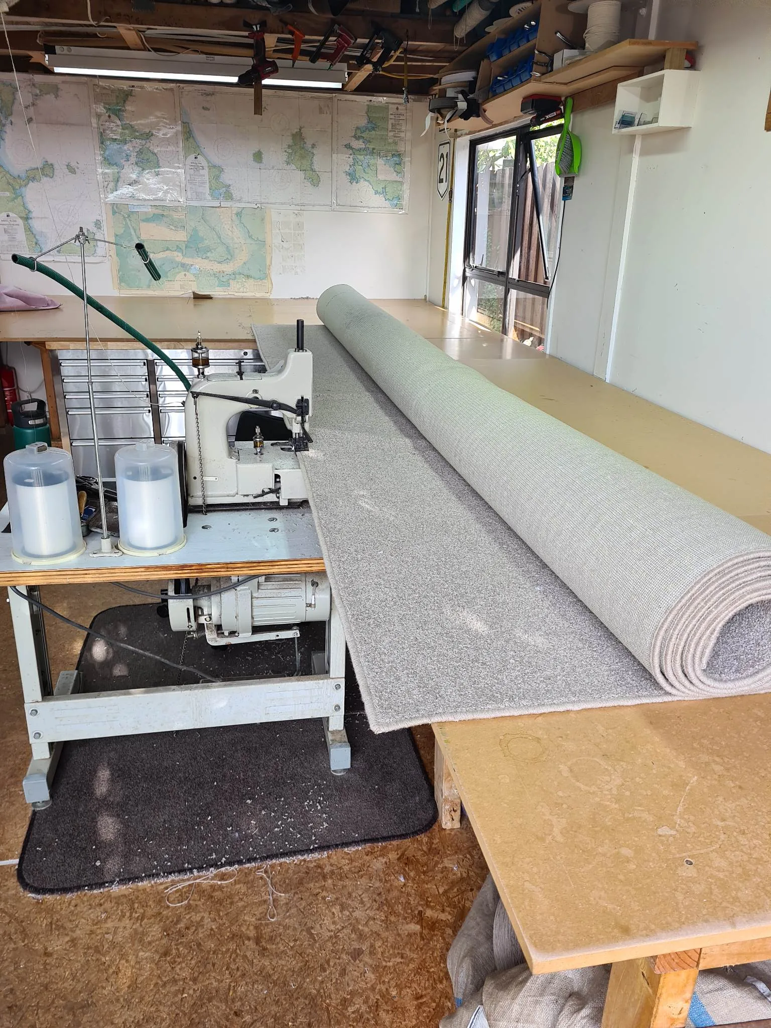 Custom grey home rug being overlocked on industrial machine in Auckland workshop