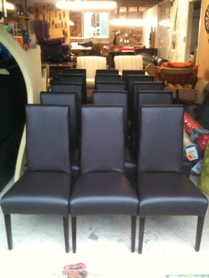 Commercial dining chairs upholstered in dark leather-look vinyl